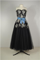 1953 evening dress. This is an evening dress bought by the donor in 1953 and it has a matching net jacket or bolero. Strapless dresses were very fashionable in the 1950s. Full skirts like the one on this dress were held out with layers of stiff petticoats